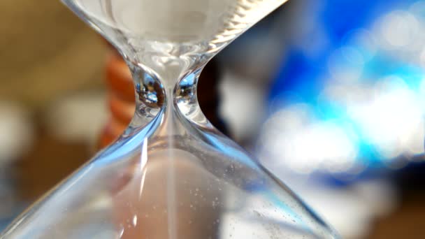 Fondo de Navidad y Año Nuevo con regalos, cintas, bolas y diferentes decoraciones verdes sobre fondo de madera. Reloj de arena de madera mide el tiempo hasta las vacaciones . — Vídeos de Stock