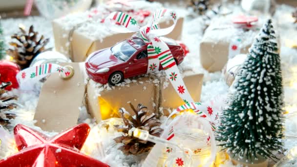 Christmas and New year background with toy car present with ribbon. Balls, pinecones and different decorations on snow. — Stock Video