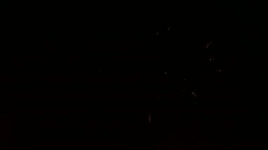 Karanlık gece gökyüzünde renkli havai fişek.