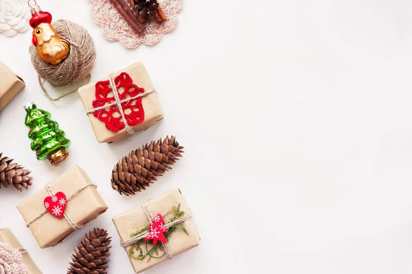 Kézzel készített ajándékok karácsonyi és újévi hátterű papír kézműves és a dekoráció, holiday szimbólumok csomagolva. Hely a szöveg. — Stock Fotó