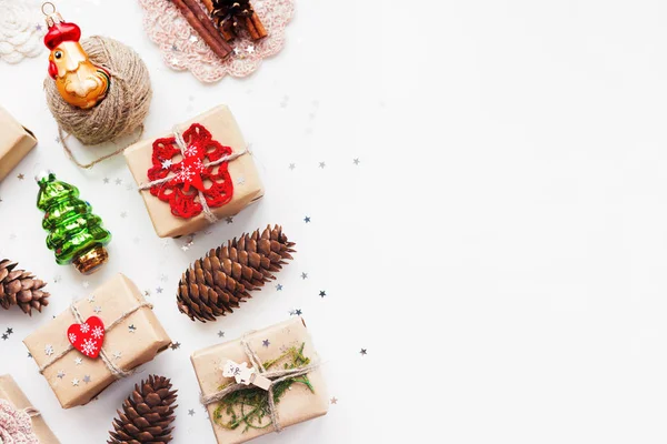 Kézzel készített ajándékok karácsonyi és újévi hátterű papír kézműves és a dekoráció, holiday szimbólumok csomagolva. Hely a szöveg. — Stock Fotó