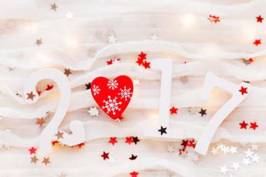 Noel ve yeni yıl 2017 arka plan. Kırmızı kalp, ampuller ve beyaz kumaş üzerine konfeti.