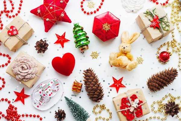 Natal e Ano Novo fundo com decorações. Presentes em papel artesanal, cones de pinho, corações vermelhos e confetes. Deitado plano, vista superior . — Fotografia de Stock