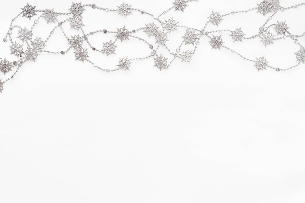 Fundo branco claro com borda de corrente de prata com flocos de neve. Natal e Ano Novo fundo feriado com lugar para texto. Deitado plano, vista superior . — Fotografia de Stock