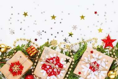 Mazı (bitki) şube, süsleri ve hediyeleri Noel ve yeni yıl arka plan kar taneleri ile Kraft kağıt sarılı. Düz yatıyordu, en iyi görünümü.