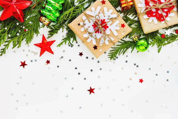 Mazı (bitki) şube, süsleri ve hediyeleri Noel ve yeni yıl arka plan kar taneleri ile Kraft kağıt sarılı. Düz yatıyordu, en iyi görünümü. — Stok fotoğraf