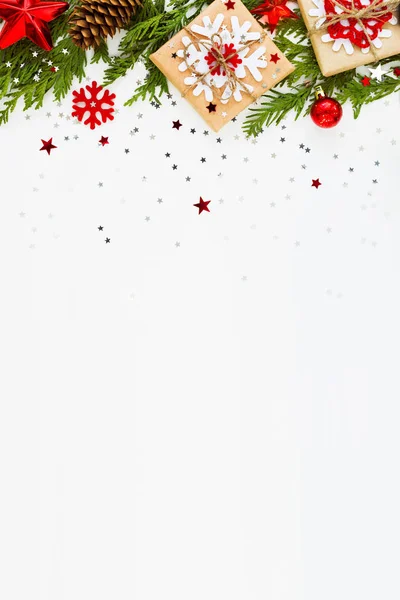 Karácsonyi és újévi háttér thuja ág, a dekoráció és a ajándékokat csomagolni a kézműves papír hópelyhek. Lapos feküdt, felső kilátás. Hely a szöveg. — Stock Fotó