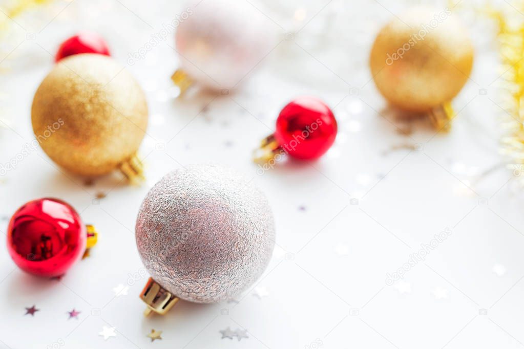 Christmas and New Year background with golden and red decorative balls for Christmas tree with light bulbs and confetti. Place for text.