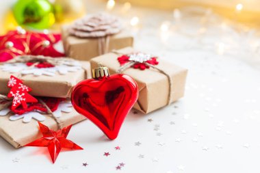 Noel ve yeni yıl arka plan kırmızı dekoratif kalp, hediyeler ve süslemeleri Noel ağacı için. Tatil yıldız konfeti ve ampul arka plan. Metin için yer.