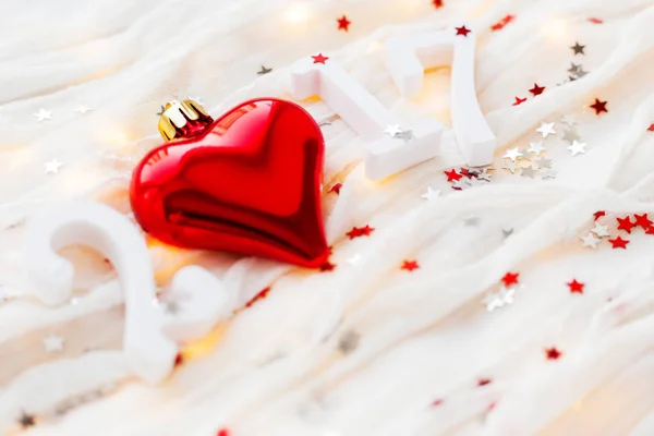 Fondo Navidad y Año Nuevo 2017. Corazón rojo, bombillas y confeti sobre tela . — Foto de Stock