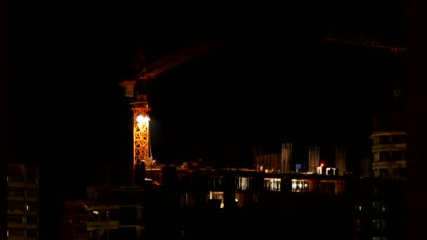 ODINTSOVO, RUSSIE - 20 octobre 2015. Timelapse clip de la construction du bâtiment la nuit. Les ouvriers en uniforme orange construisent un immeuble. La grue de construction se déplace d'un côté à l'autre . — Video