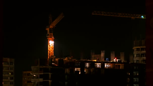 ODINTSOVO, RUSSIE - 20 octobre 2015. Timelapse clip de la construction du bâtiment la nuit. Les ouvriers en uniforme orange construisent un immeuble. La grue de construction se déplace d'un côté à l'autre . — Video