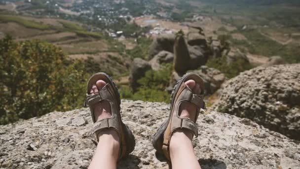 Jambes des hommes dans les chaussures brunes couchées sur les rochers sur le fond de la montagne — Video