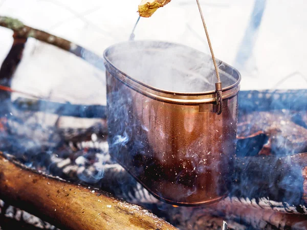 Cocinar sopa en una olla de fuego. Camping de invierno en bosque . — Foto de Stock