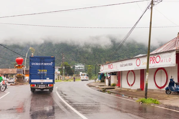 Kintamani, Endonezya - 26 Ocak 2013. Ağır Sis yolda, motosiklet sürüş için kötü hava. Puslu herdem yeşil orman orman yolda. Kış yağmur mevsimi. Endonezya.