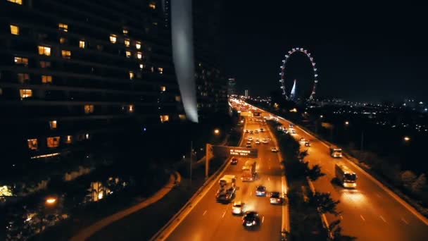 Vägtrafiken i natt. Bilar med tända strålkastare kommer på vägen. Singapore. — Stockvideo