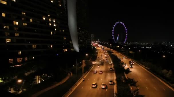 Tráfico por carretera en la noche. Coches con faros encendidos en la carretera. Singapur . — Vídeo de stock