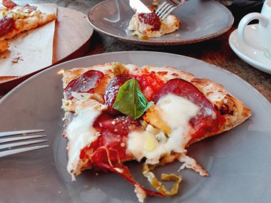 Bir parça peynir, jalapenos biber, domates ve fesleğen taze sıcak pizza. Lezzetli İtalyan yemekleri.