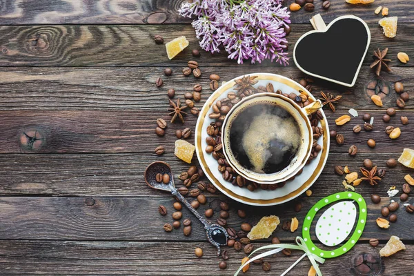 Rustieke houten achtergrond met kopje koffie en Pasen versieringen. Warme drank met hart schoolbord. Bovenaanzicht, plaats voor tekst. — Stockfoto