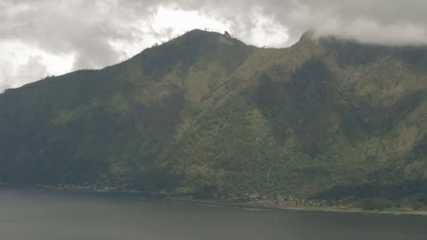 Batur vulkán, panoráma a Kintamani. Vulkán tájkép erdővel, téli esős évszak felhős nap. Bali, Indonézia — Stock videók