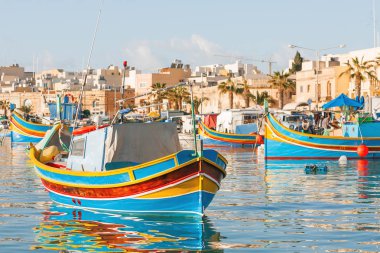 Mediterranean traditional colorful boats luzzu. Fisherman village in the south east of Malta. Early winter morning in Marsaxlokk, Malta. clipart