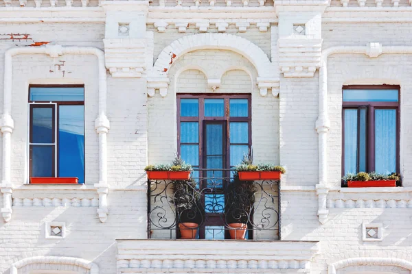 Gevel van het huis met ramen en balkon. Gedessineerde muur gemaakt van witte bakstenen. Decoratieve smeedijzeren hek van het balkon. Moskou, Rusland. — Stockfoto