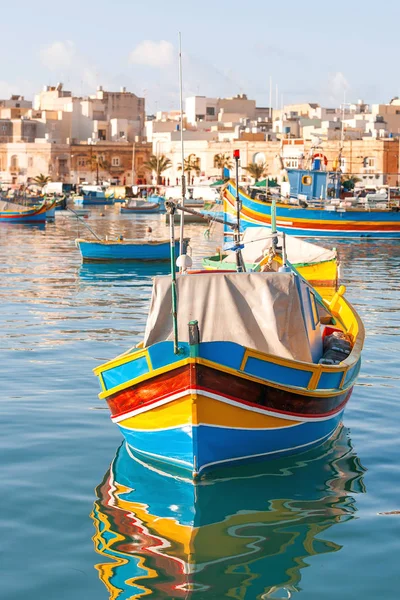 Mediterranean traditional colorful boats luzzu. Fisherman village in the south east of Malta. Early winter morning in Marsaxlokk, Malta. Stock Photo