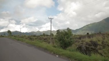 Bir bisiklet sürüş volkan Batur geçmiş. Kintamani Panorama manzara. Peyzaj stüdyo kış yağmur mevsimi, bulutlu gün orman ve tarım alanları ile. Bali Endonezya