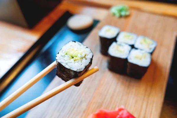 Rollos en algas nori con aguacate, jengibre en escabeche y salsa de soja. Cocina asiática, plato tradicional - sushi . — Foto de Stock