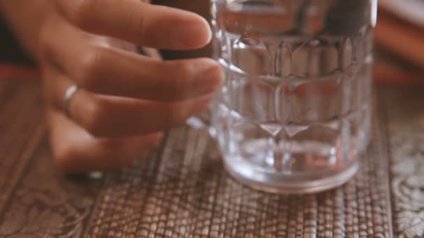 Mujer golpeando clavos en un vaso empañado de agua fría y deslizando la pantalla de la tableta. Camboya . — Vídeo de stock