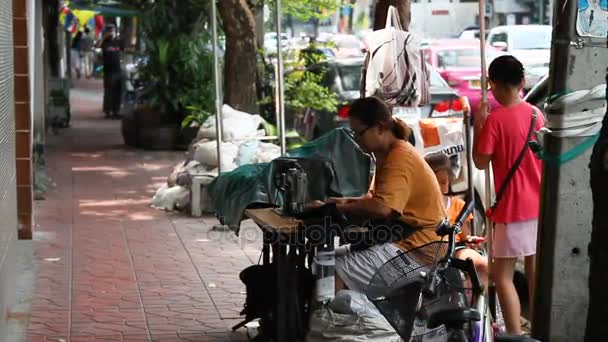 Bangkok, Tajlandia - października 20, 2012. Mały sklep na ulicy krawiec. Kobiety szyje coś na maszyny do szycia. Tradycyjne życie w Azji miasta. — Wideo stockowe