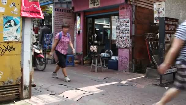 БАНГКОК, ТАИЛАНД - 20 октября. Уличная жизнь Бангкока. Люди проходят мимо парикмахерской, кафе и массажного салона . — стоковое видео