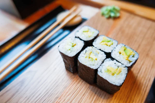 Rollos en algas nori con aguacate, jengibre en escabeche y salsa de soja. Cocina asiática, plato tradicional - sushi . — Foto de Stock