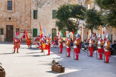 VALLETTA, MALTA - February 21, 2010 - Knights of the Order of St. John during reenactment. Tourists watch the performance from from the fenced places. clipart