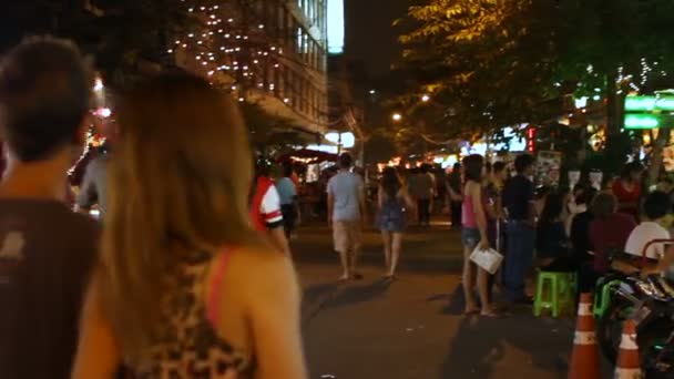 Bangkok, Thailand - 22 oktober 2012. Nachtleven op Khao San road. Locals en toeristen zitten in cafés en restaurants, versierd met kleurrijke lampen en lantaarns, lopen in de straat. — Stockvideo