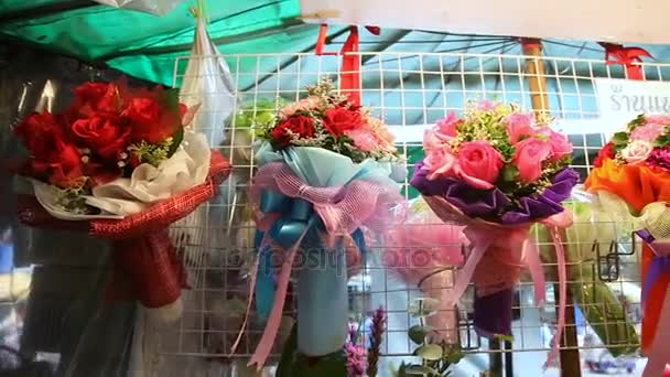フラワー マーケットに花束を紹介します。刈り取らバラは色紙、サイザル麻、リボンで飾られました。バンコク、タイ. — ストック動画