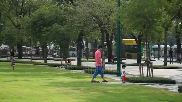 BANGKOK, THAILAND - 22 de outubro de 2012. Um homem local a andar com o filho no parque. Lazer familiar . — Vídeo de Stock