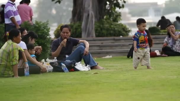 BANGKOK, THAÏLANDE - 20 octobre 2012. Loisirs en famille dans le parc. Pique-nique sur l'herbe. Les paernes mangent, les enfants jouent. La vie de rue habituelle à Bangkok . — Video