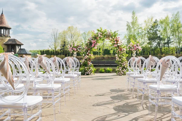 Beautiful floral arch for wedding ceremony. Vases with pink rose