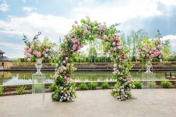 Güzel çiçek arch düğün töreni için. Vazo pembe Gül ve peonies. Düğün gölet yakınındaki Park açık havada ayarla.