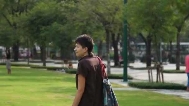 Turista sonriendo felizmente en el campo en el parque frente al Palacio Real. Bangkok, Tailandia . — Vídeo de stock