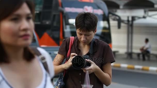 Bangkok, Tajlandia - października 20, 2012. Kobieta turystyczny strzela coś. Kobieta, wiszące na jego ramię sok w torbie. — Wideo stockowe