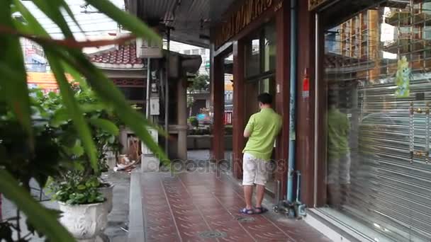 バンコク, タイ王国 - 2012 年 10 月 20 日。中国町地区の街の生活。植物と通りを歩く人々. — ストック動画