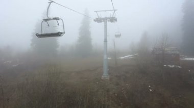 Turistleri teleferik sis ile kabin devam. Sabah erken gezi yukarıda Mestia, Gürcistan'daki sisli orman.
