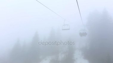 Turistleri teleferik sis ile kabin devam. Sabah erken gezi yukarıda Mestia, Gürcistan'daki sisli orman.