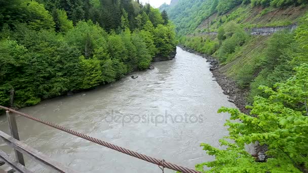 Swingende hangbrug over de rivier van een berg. Land van Svaneti (Georgia). — Stockvideo