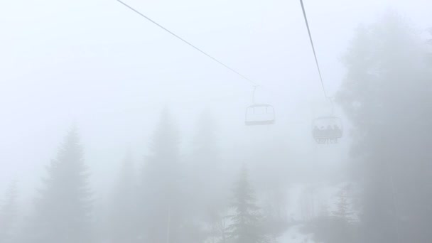 Turister gå i stugor på ropewayen genom dimman. Tidig morgon resa över dimmiga skogen i Mestia, Georgien. — Stockvideo