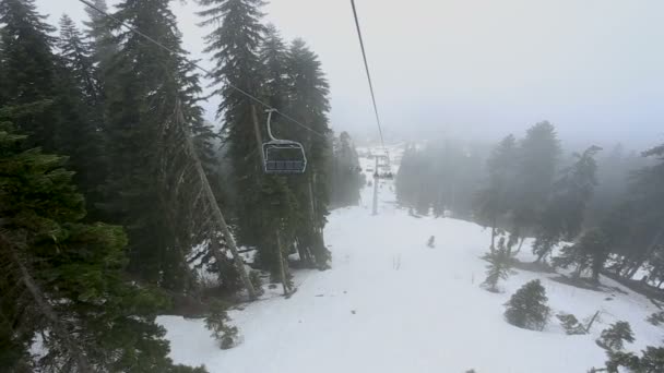 A turisták a kabinok a megy a drótkötélpályához ködben. Kora reggel utazás felett ködös erdő Mestia, Grúzia. — Stock videók