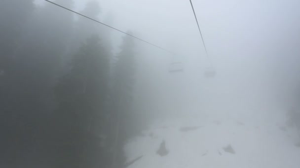 Turister gå i stugor på ropewayen genom dimman. Tidig morgon resa över dimmiga skogen i Mestia, Georgien. — Stockvideo