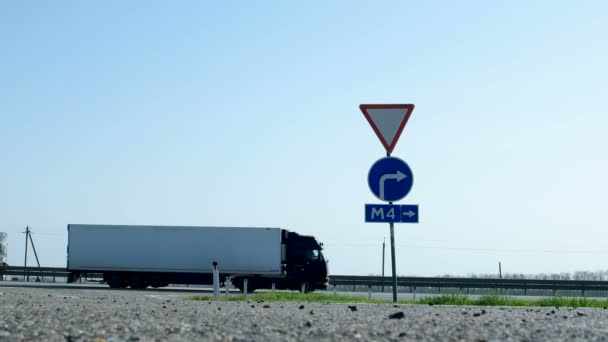 Straßenschild - Einfahrt zur mautpflichtigen Autobahn m4 don. Lastwagen und Autos fahren an einem Verkehrsschild vorbei. — Stockvideo